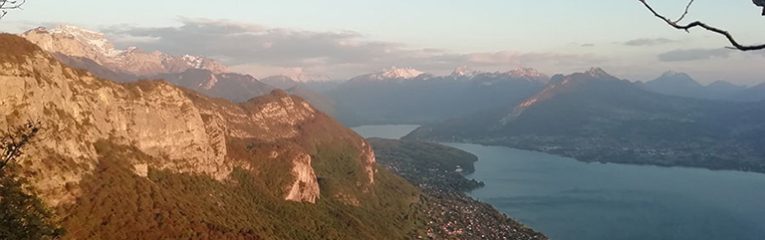 Vue panoramique sur le lac d'Annecy et les montagnes environnantes. Paysage naturel au coucher de soleil, idéal pour les activités en plein air et le tourisme dans les Alpes françaises