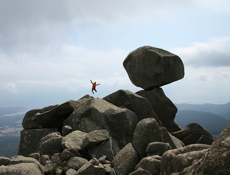 Homme qui saute par dessus une montagne en Corse